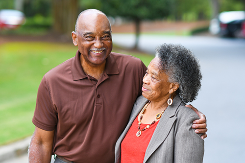 African american couple standing outside hugging and smiling 